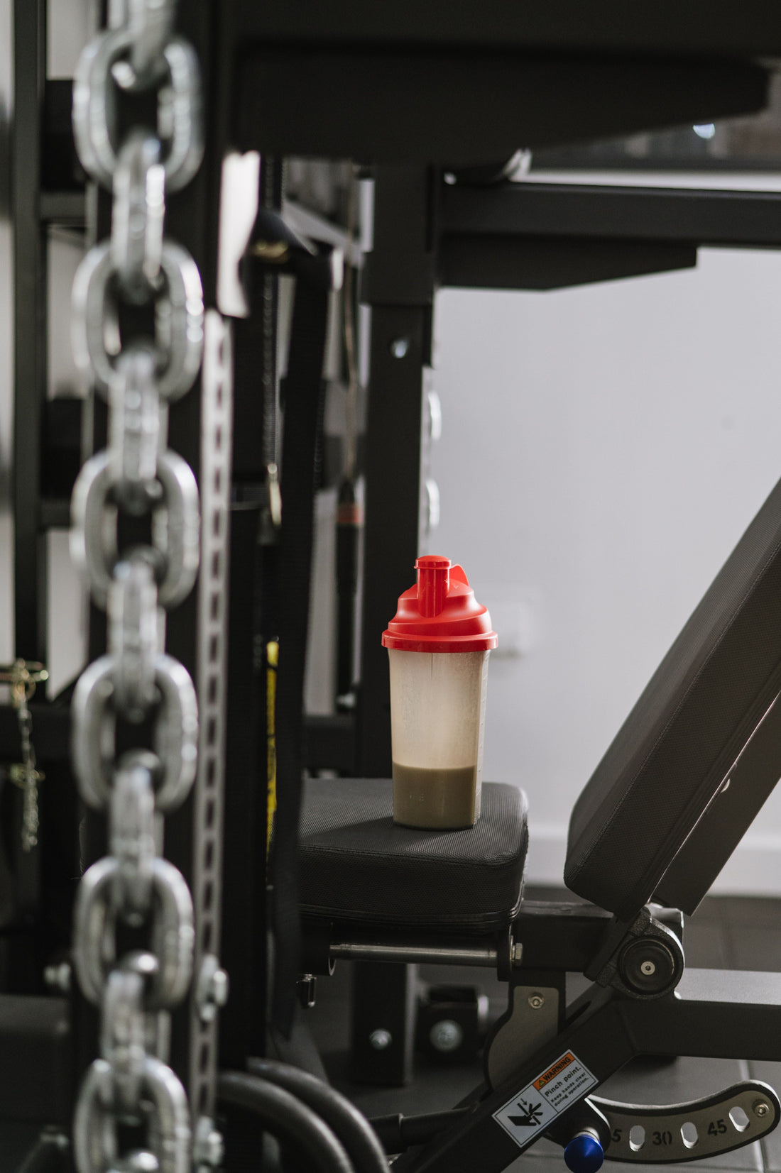 Protein shaker resting on gym equipment before a workout